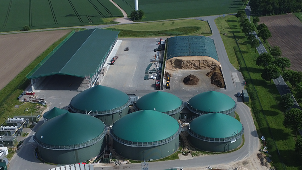 Vergrößerung des Bildes für Auf dem Bild sieht man von oben auf eine Biogasanlage und das Gelände um die Anlage..