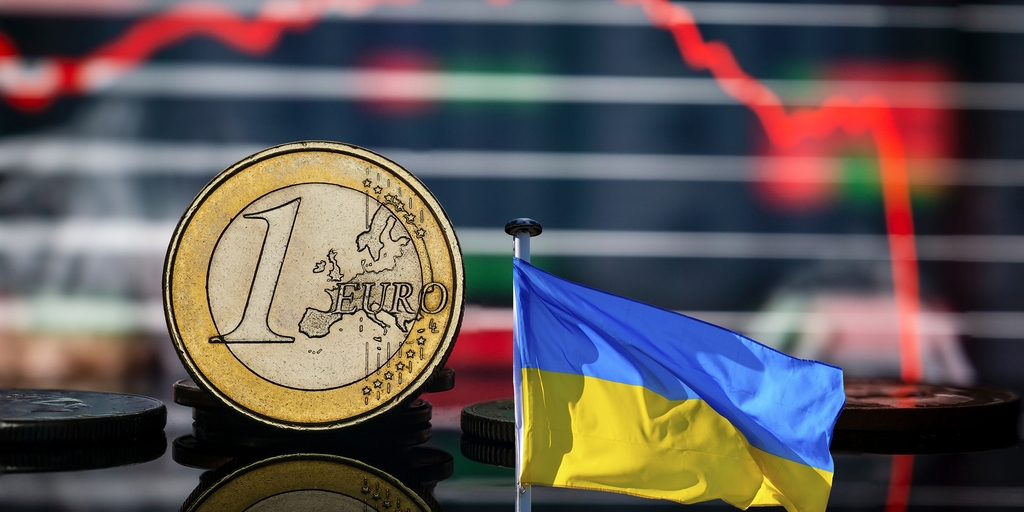 Ein Euro und die Fahne der Ukraine. Im Hintergrund ein absteigendes Diagramm vom Börsenkurs.