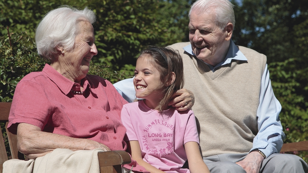 Vergrößerung des Bildes für Senioren mit Enkelkind auf einer Bank.