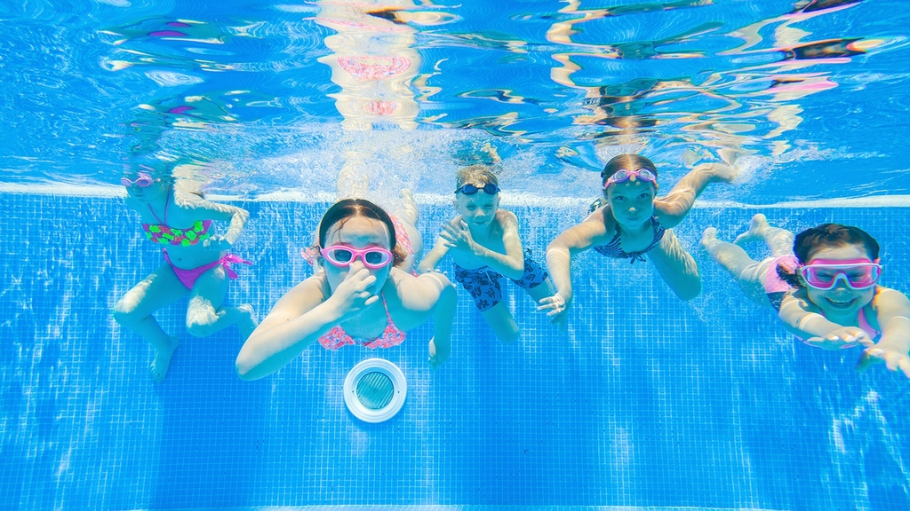 Vergrößerung des Bildes für Unterwasseraufnahme von Kindern, die im Pool schwimmen.