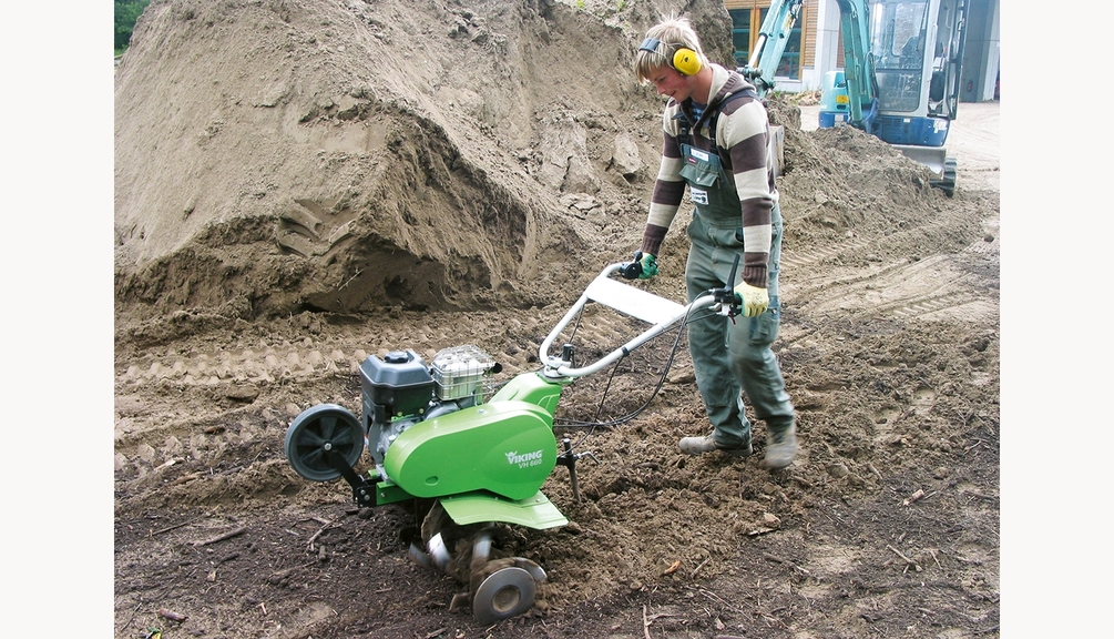 Arbeiter in Schutzkleidung bei der Bodenbearbeitung mit einer triebradlosen Motorhacke