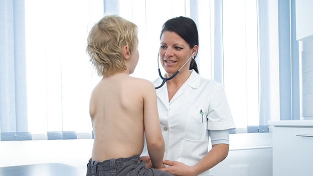 Eine Ärztin untersucht ein Kleinkind mit einem Stethoskop
